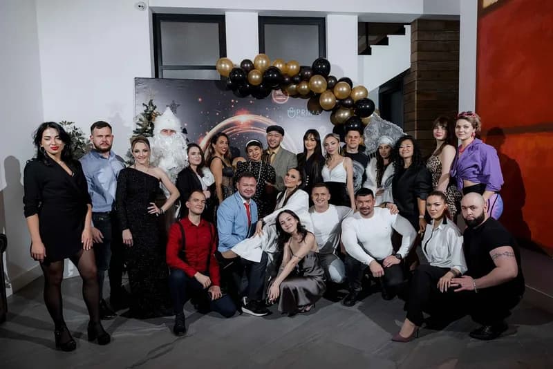 Команда коллег фотографируется у новогодней фотозоны на корпоративе