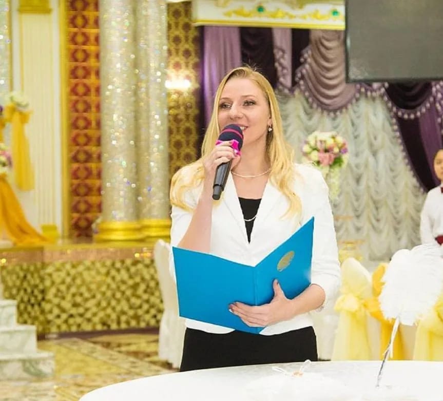 Елена Архипова, ведущая торжеств, с микрофоном и папкой в банкетном зале